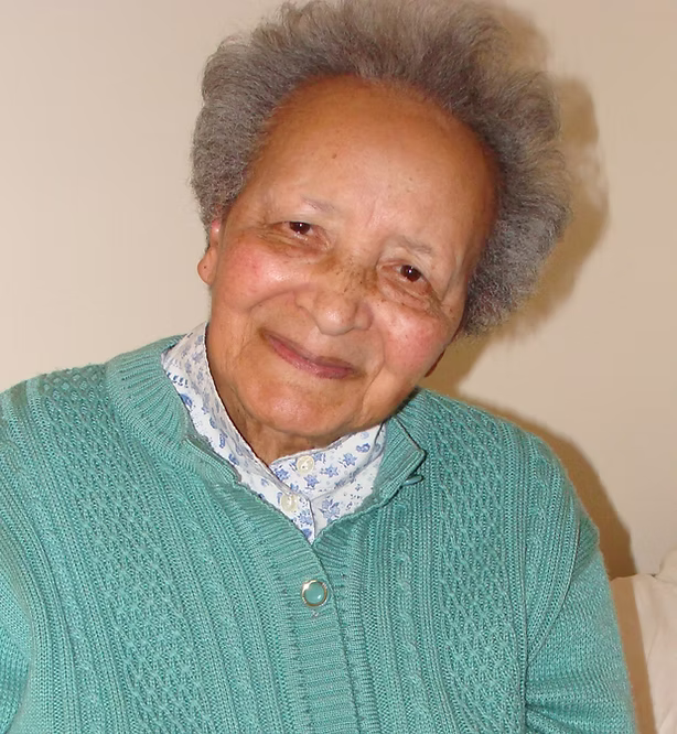 Augusta Chiwy wearing green sweater, smiling for photo