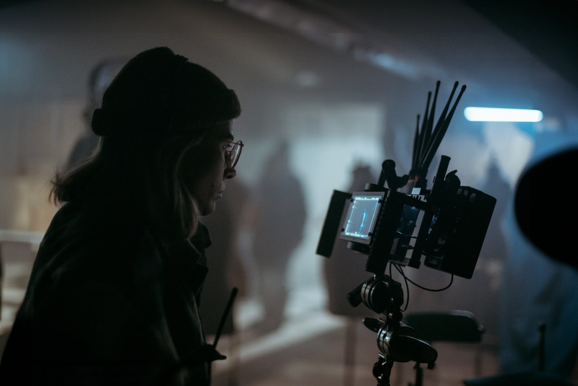 Woman wearing hat and glasses looking at camera while film is being recorded