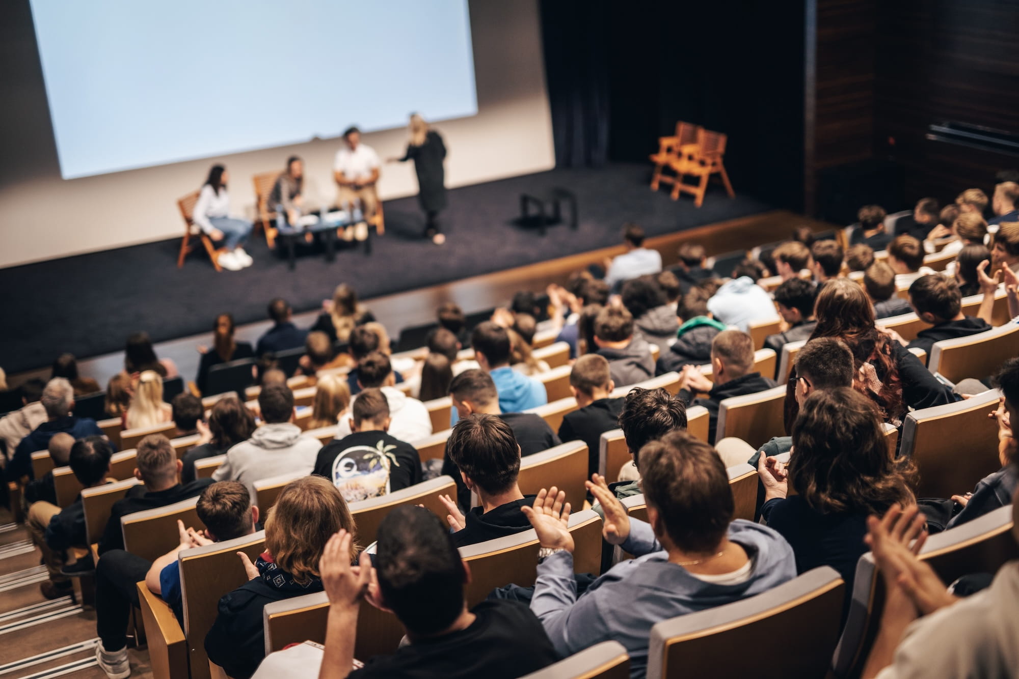 Lectures with students sitting in large auditorium