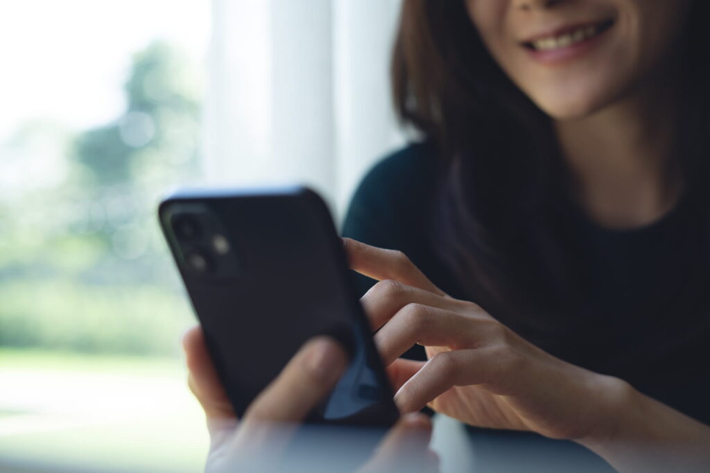 Woman checking phone, smiling