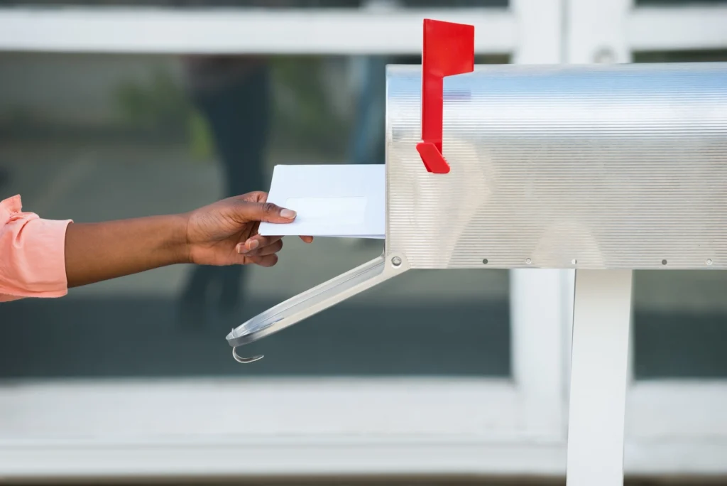Woman putting letters into mailbox